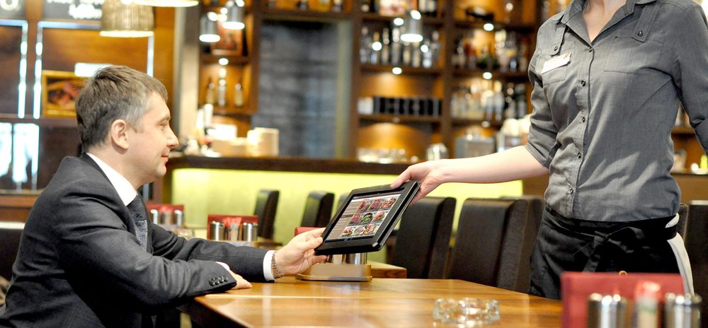  Businessman viewing digital menu on tablet at Restaurant 