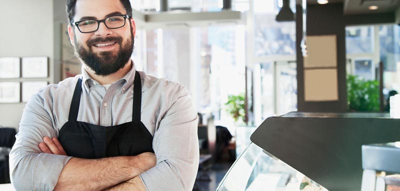  Man behind a counter with arms crossed 